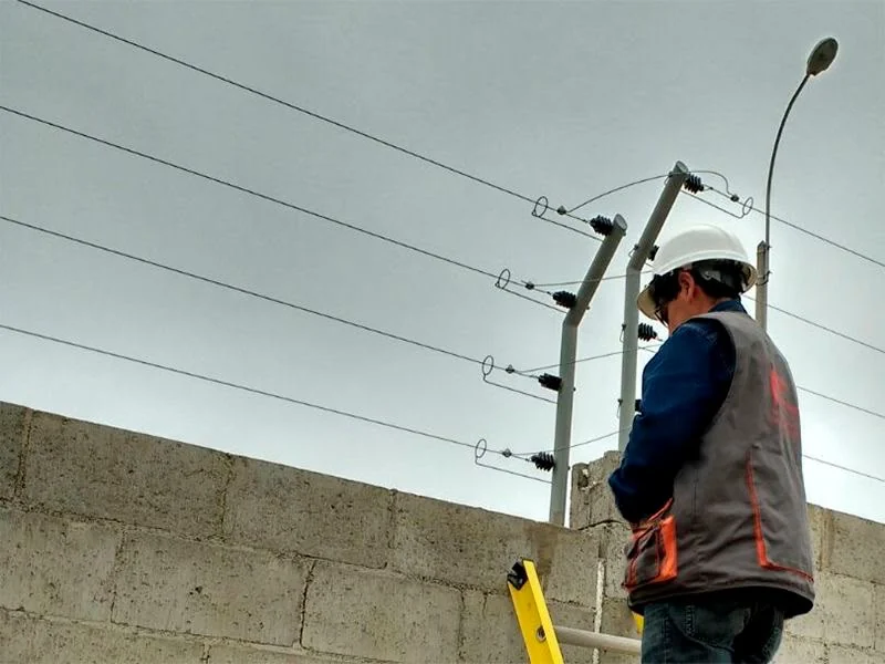 Instalación de líneas y aisladores de un cerco eléctrico sobre una barda.