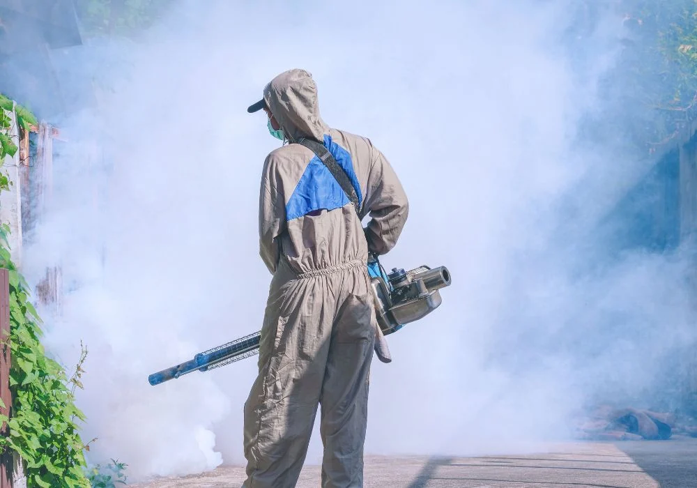 Aplicación de tratamiento para control de plagas con equipo de protección.